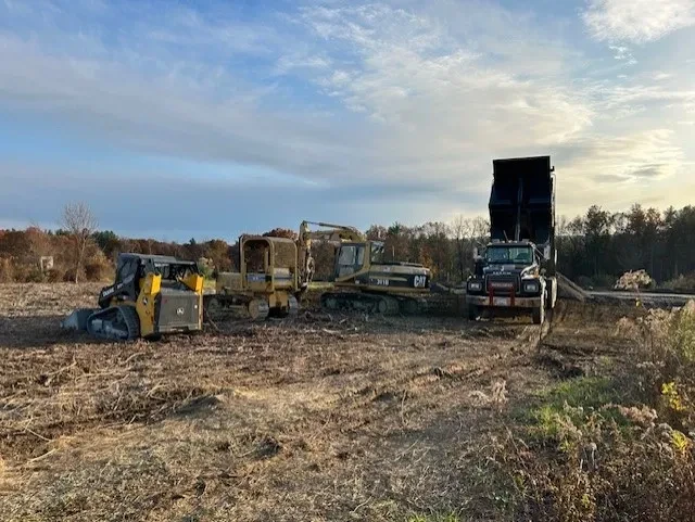Mercurio Mack trucks and CAT bulldozer at site clearing job