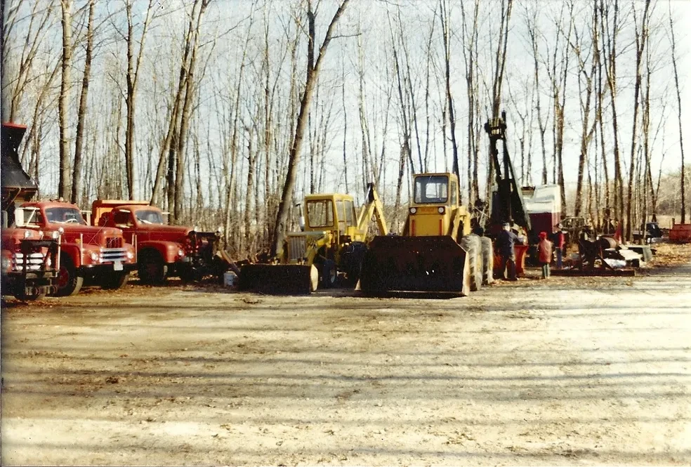 Excavators and Mack trucks lined up at yard